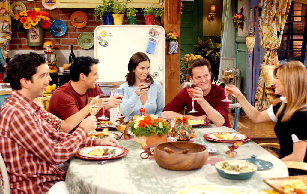 Men and women sitting around a holiday table giving a toast